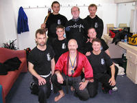 The successful Fire Dragon team, in their dressing room at Fox Studios. Back: Shr Fu Bellchambers with the 14 lb sledge, Shane Bartleman, Brendan Hayes. Middle: Stephen Wells, David Connell; Front: Geoff Wilmot, Master Hardy, Wasu Jayne Hardy
